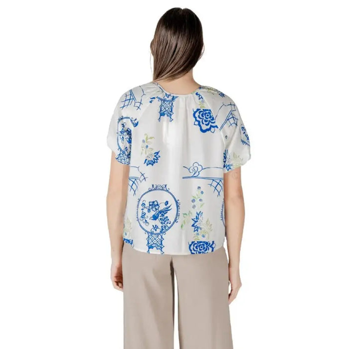 Woman wearing a patterned blouse and tan pants from Womens Patterned Blouse and Pants collection