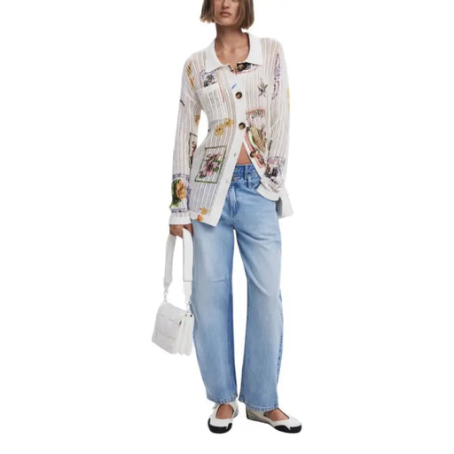 Woman wearing a white patterned knit cardigan and blue jeans outfit for a stylish look