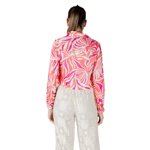 Elegant woman wearing a patterned long-sleeved blouse and textured pants for women