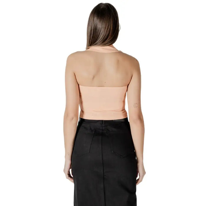Woman wearing peach halter top and black skirt showcasing style and elegance