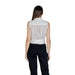 Woman wearing a white sleeveless sheer V-neck zip top with black pants for Fall Winter fashion