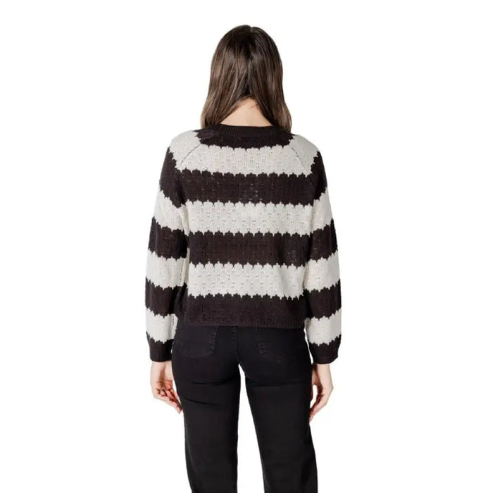 Woman wearing a striped knit sweater and black pants, perfect for casual wear