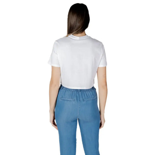 Woman wearing a white crop top and blue pants from Only Women T-Shirt collection