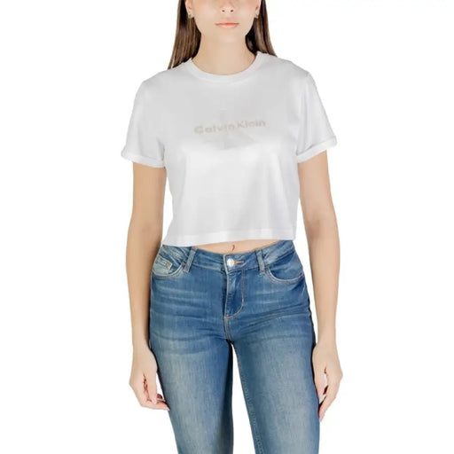 Woman wearing a white crop top and blue jeans displayed in the product listing