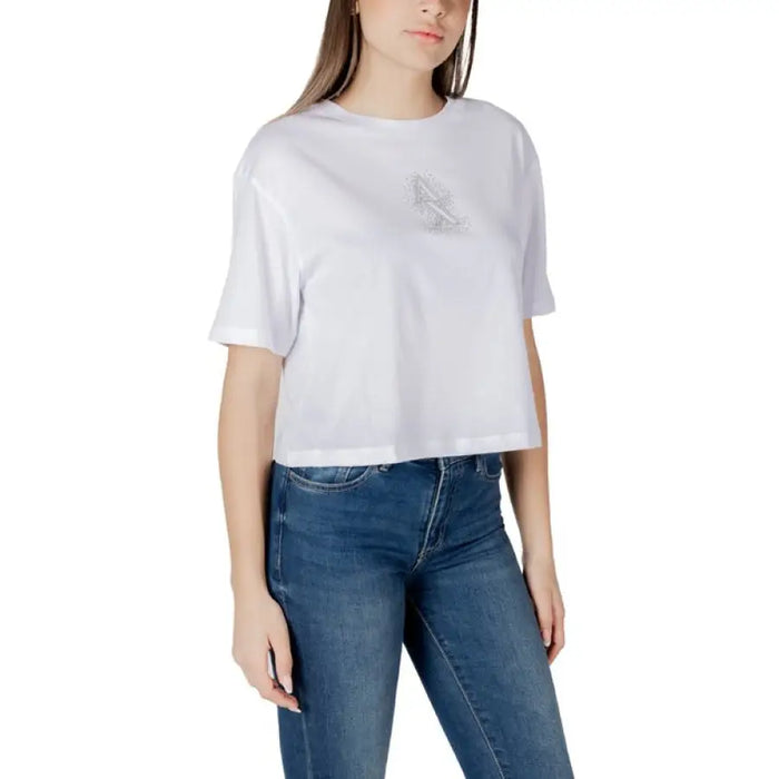 Woman wearing a white cropped T-shirt paired with blue jeans in a fashion showcase