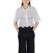 Woman wearing white eyelet shirt and black pants from Women’s Black Eyelet Shirt and Denim Shorts collection