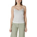 Woman wearing a white lace-trimmed camisole and green pants for Women’s White Lace Trim Camisole and Green Pants