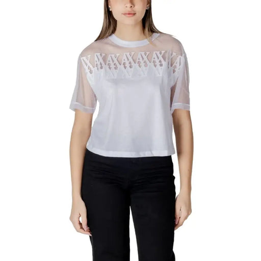 Woman wearing a white sheer-overlay top with black pants in Black Mesh Overlay Two Piece Set