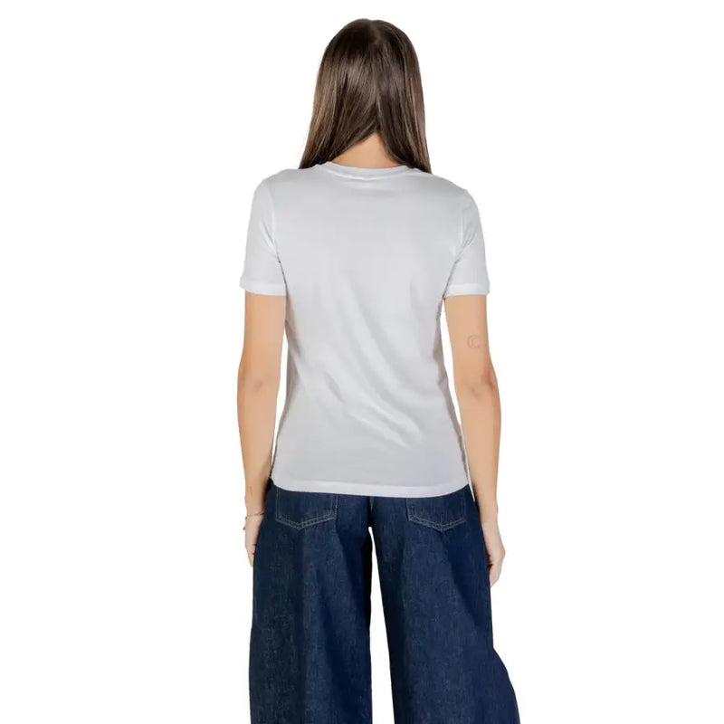 Woman wearing white 100% cotton short sleeve crew-neck T-shirt and wide-leg dark wash jeans