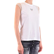Woman wearing white sleeveless cotton tank top with ruffled shoulders and distressed black jeans