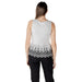 Woman wearing a white sleeveless top with black floral trim for the product White Sleeveless Top with Black Floral Trim