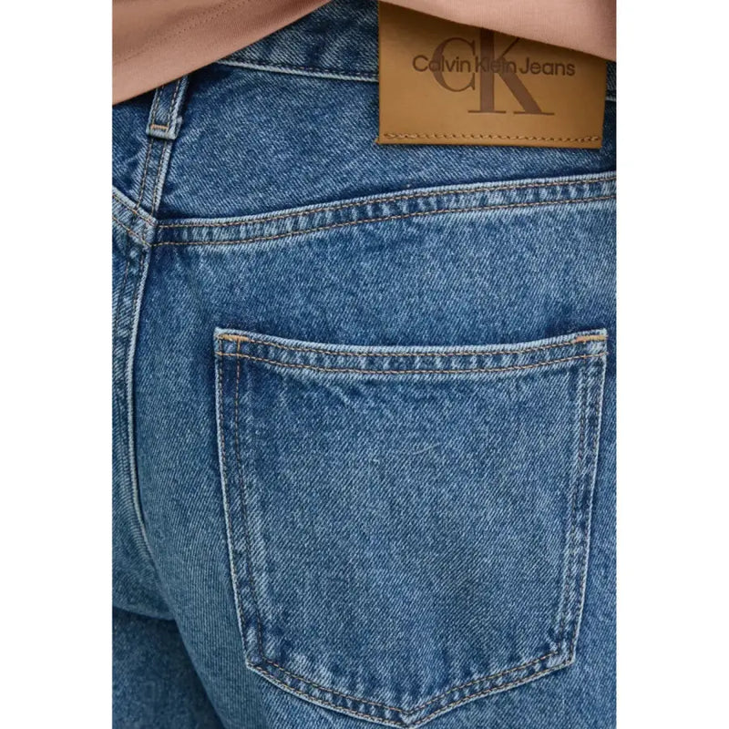 Blue denim women’s casual jeans shown from the back featuring a brown leather calvin klein brand patch on waistband