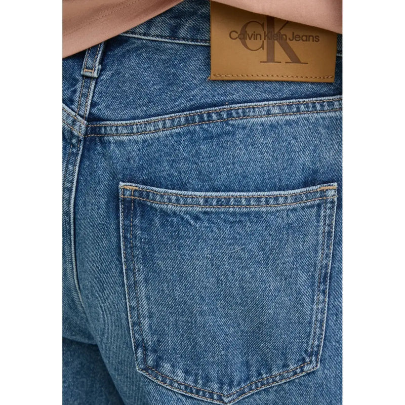 Blue denim women’s casual jeans shown from the back featuring a brown leather calvin klein brand patch on waistband
