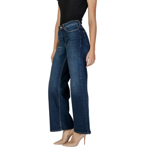 Woman wearing dark blue wide-leg jeans and a black top from Womens Blue Jeans with Zip Button Closure and Pockets