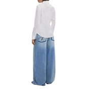 Women wearing white button-up shirt and oversized light-wash blue jeans for fall winter fashion