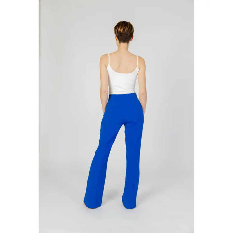 Women wearing white camisole top and blue flared trousers for spring and summer fashion