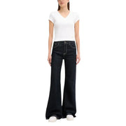 Women wearing a white V-neck short-sleeve T-shirt and dark wash flared jeans